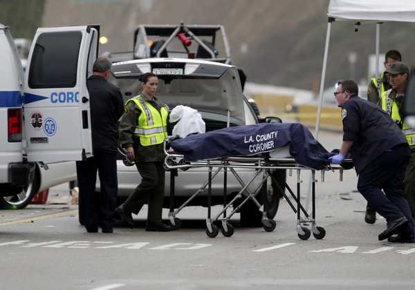 A Los Angeles County coroner worker loads a victim into a van at the scene of a four-car crash involving Olympic gold medalist and reality TV star Jenner in Malibu