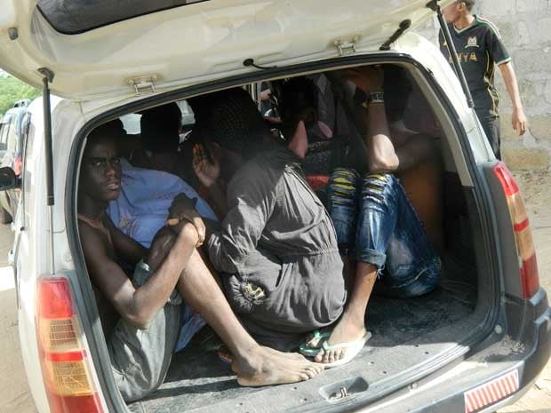 Estudantes se refugiam em um veículo durante ataque a universidade. (Foto: AP Photo)